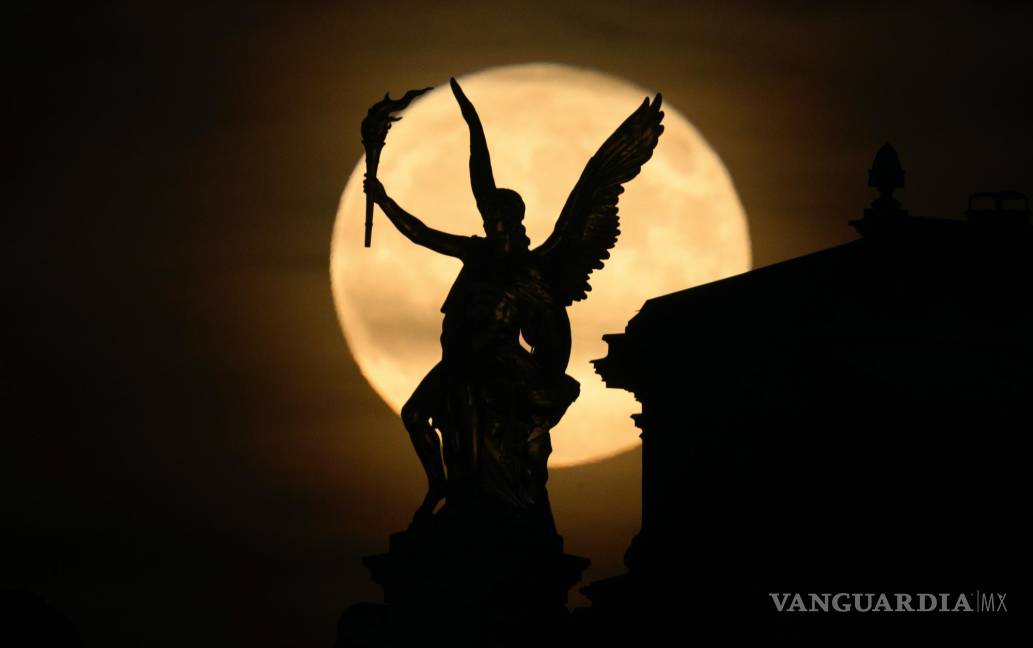 $!La luna llena sale por la noche detrás de la figura de “Eros” en la Academia de Bellas Artes en Desden. Durante el fenómeno de la “ Strawberry Moon”.