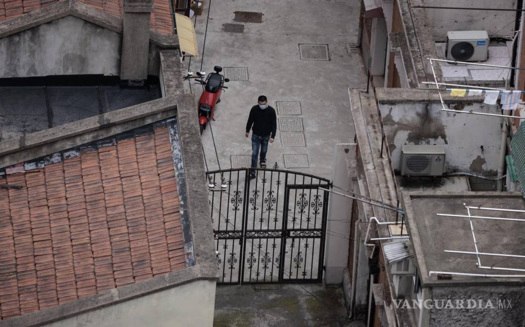 $!Un hombre camina fuera de su casa en un complejo residencial en Shanghái, China.
