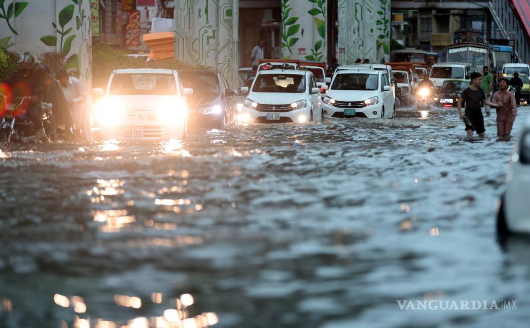 $!Los automovilistas se abren camino a través de una carretera inundada tras las fuertes lluvias monzónicas en Rawalpindi, Pakistán.