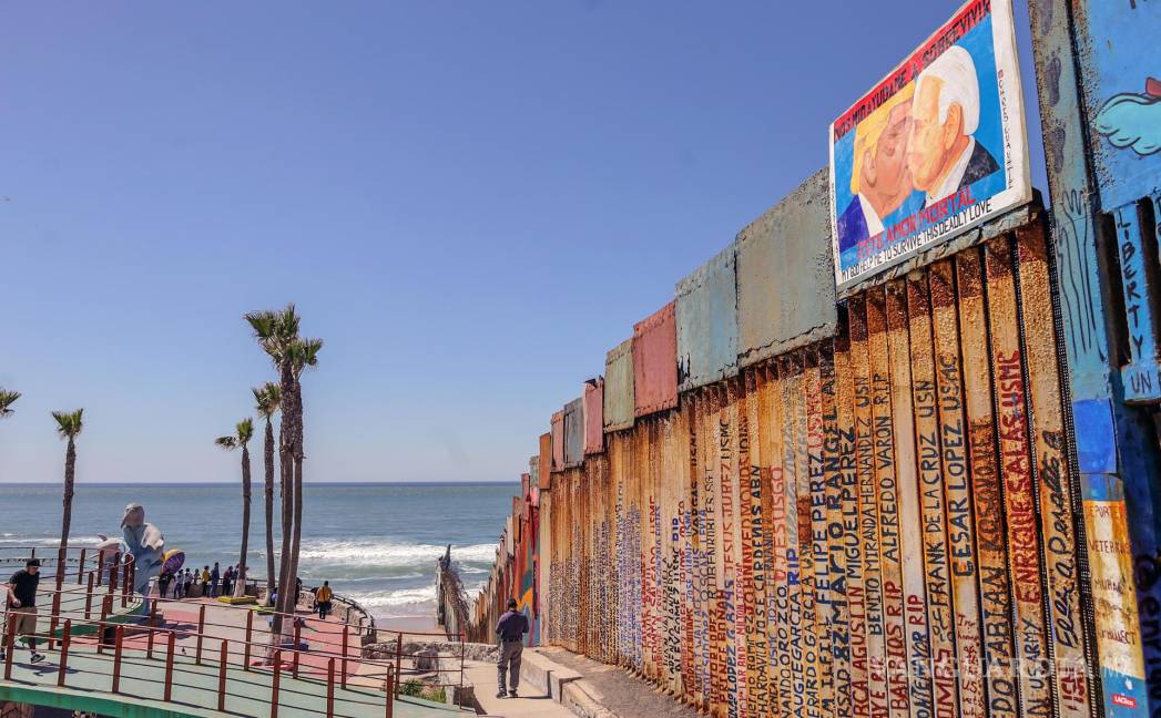 $!Vista de una imagen del expresidente estadounidense Donald Trump besando al actual mandatario, Joe Biden (d) en el muro fronterizo en la ciudad de Tijuana.