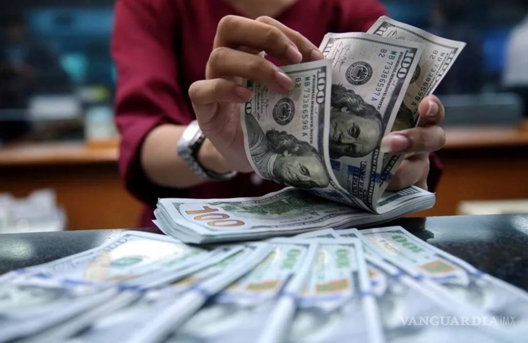 $!Una mujer cuenta billetes de 100 dólares.