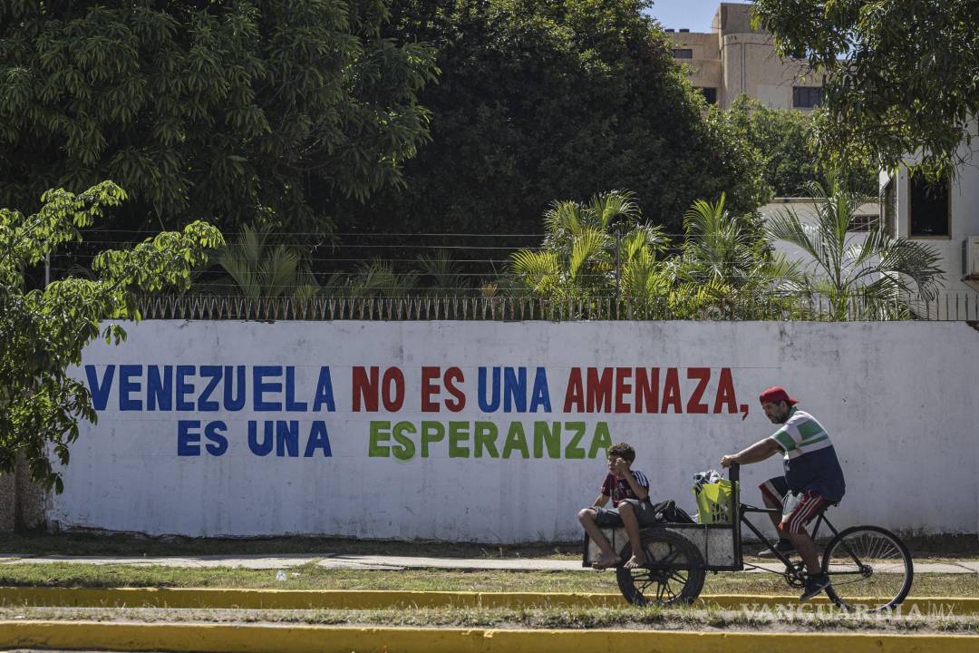 $!Personas transitan en bicicleta frente a un mural en Maracaibo, Venezuela.