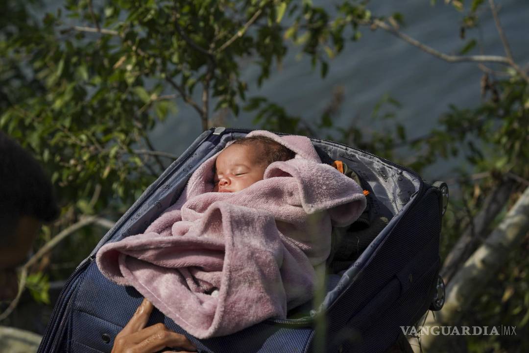 $!Migrantes cruzan el Río Bravo para entrar a Estados Unidos, con un bebé dentro de una maleta, vistos desde Matamoros, México, el 10 de mayo de 2023.