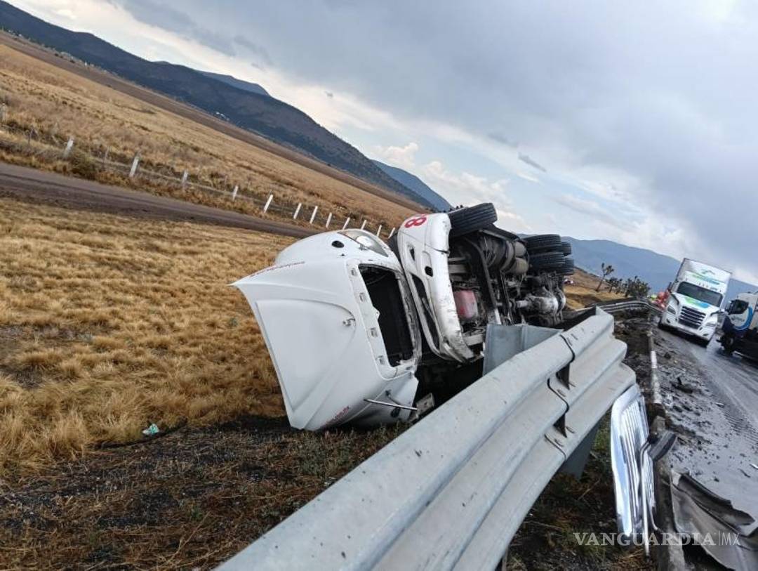 $!Uno de los tráileres involucrados quedó volcado fuera de la carpeta asfáltica, mientras continuaban las maniobras para su levantamiento.