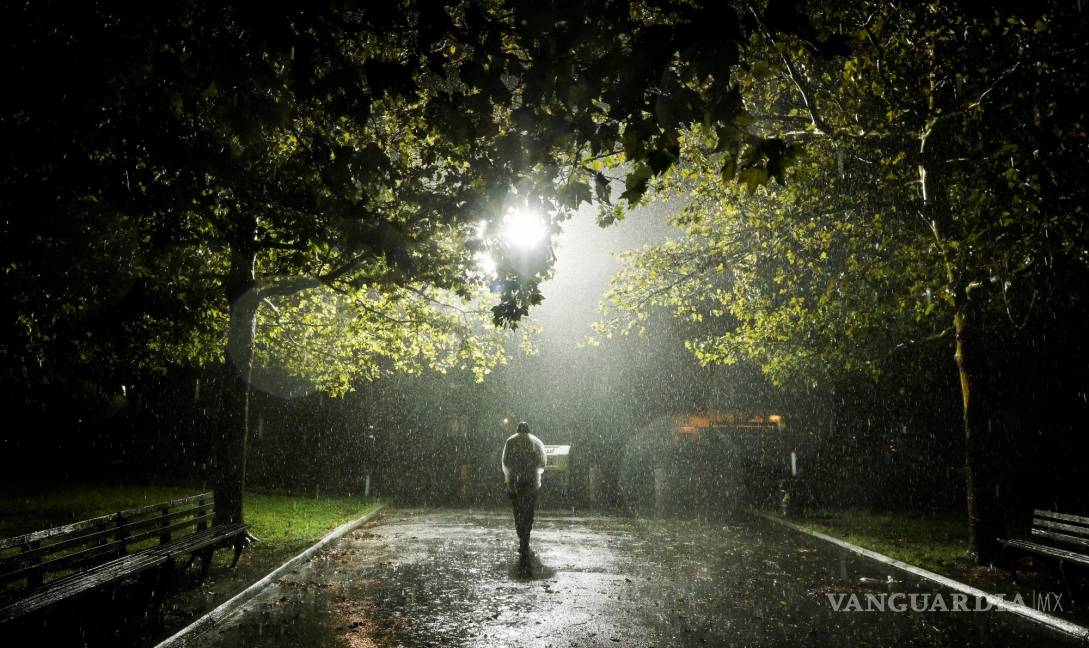 $!Un hombre camina por un parque durante una tormenta de lluvia cuando los restos del huracán Ida azotaron el área en el distrito de Queens de Nueva York, Nueva York. EFE/EPA/Justin Lane