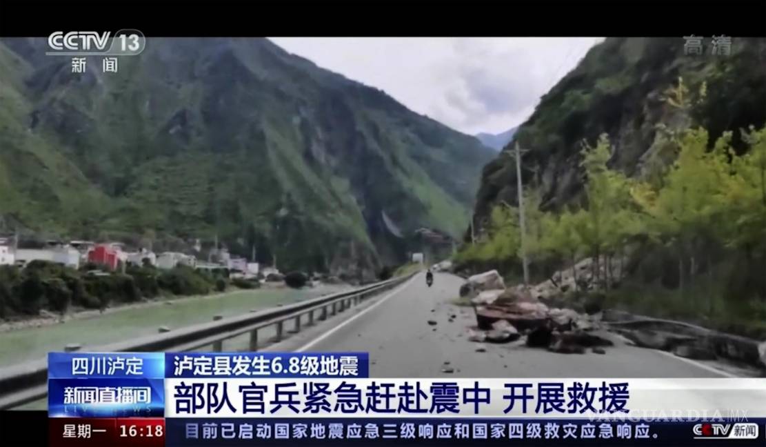 $!Los residentes pasan junto a rocas caídas en una carretera en el condado de Luding, en la provincia de Sichuan, suroeste de China.
