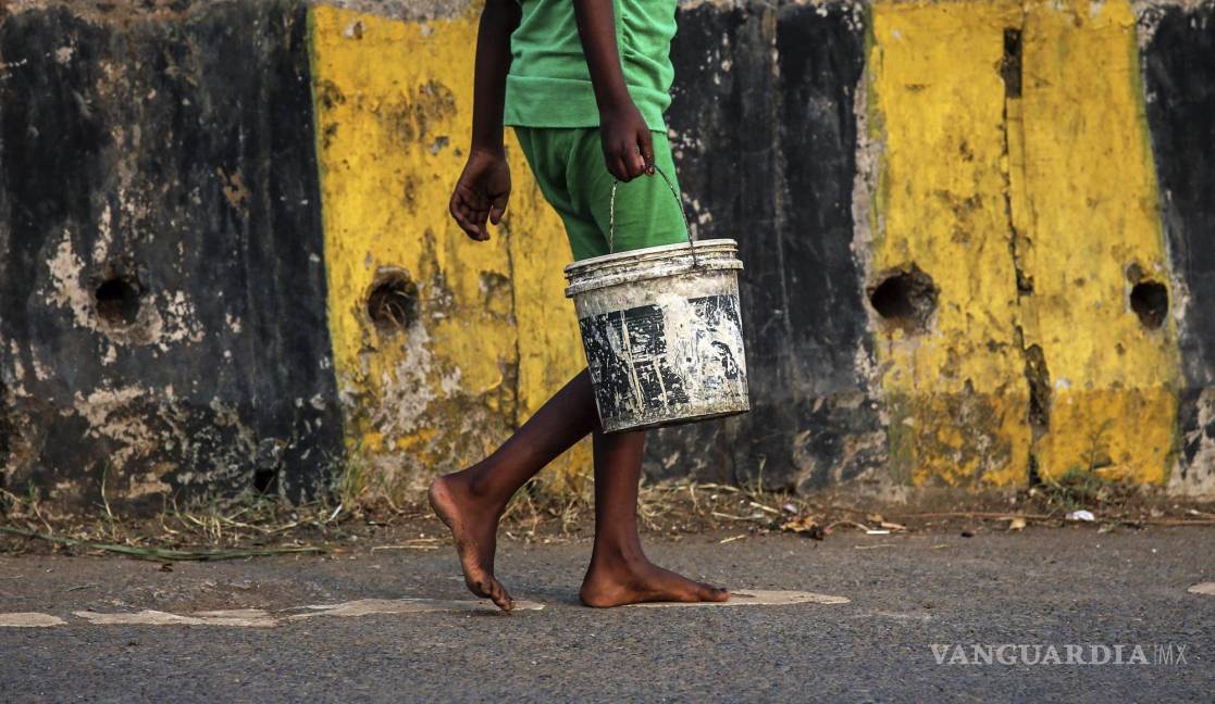 $!Una niña sostiene un cubo mientras camina hacia las letrinas a las afueras de Bombay, India. EFE/Divyakant Solanki