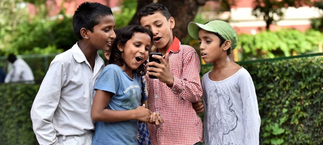 Niños en la Escuela San Columba en Delhi, India, se toman fotos con su smartphone.
