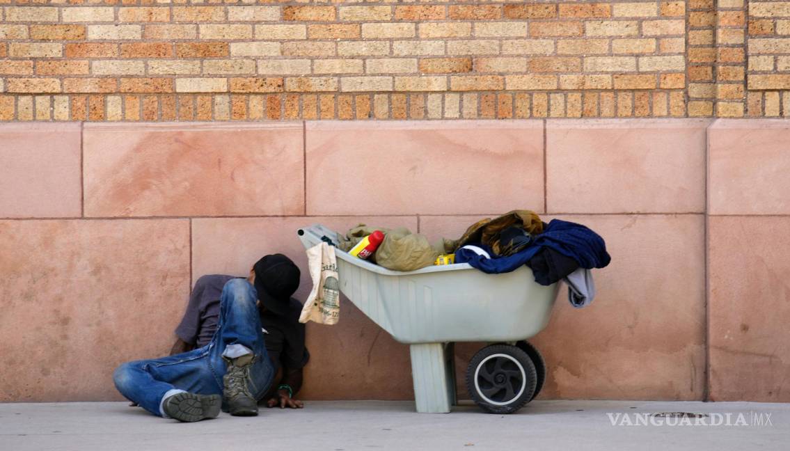 $!Un hombre duerme contra la pared de un edificio a lo largo de la calle 14 mientras las temperaturas alcanzan los 90 grados en el centro de Denver.