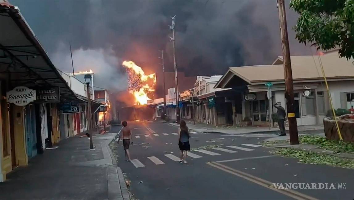 $!La gente observa cómo el humo y las llamas llenan el aire de los incendios forestales en Front Street en el centro de Lahaina, Maui en Hawái.