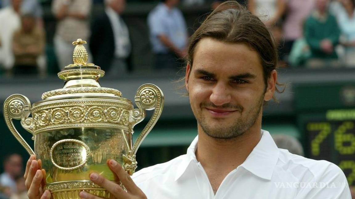 $!Roger Federer sostiene el trofeo tras de ganar la final contra Mark Philippoussis en Wimbledon, el domingo 06 de julio de 2003.