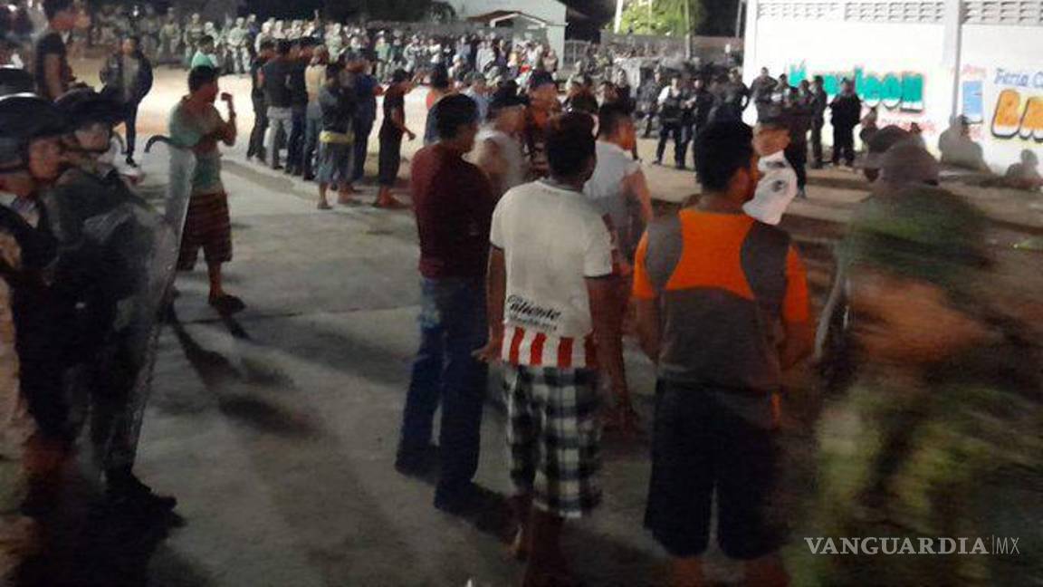 $!Habitantes rodearon el establecimiento y ante la negativa de militares de soltar al presunto homicida, prendieron fuego a dos vehículos de carga