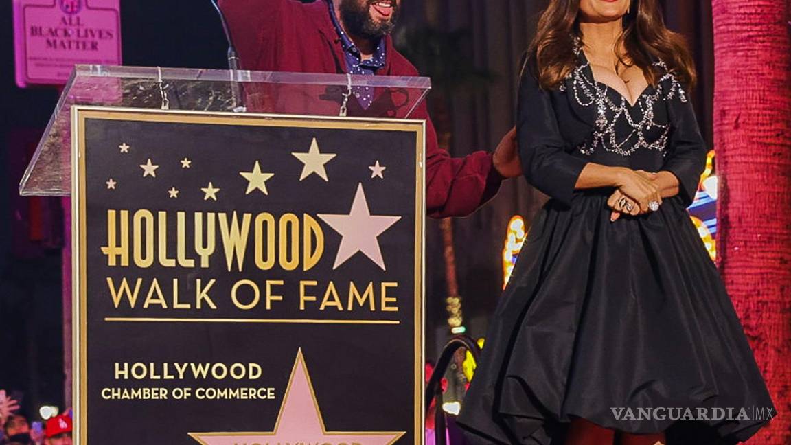 $!El actor Adam Sandler pronuncia unas palabras en nombre de la actriz Salma Hayek antes de recibir la estrella en el Paseo de la Fama en Hollywood (EU). EFE/Phillip Kim