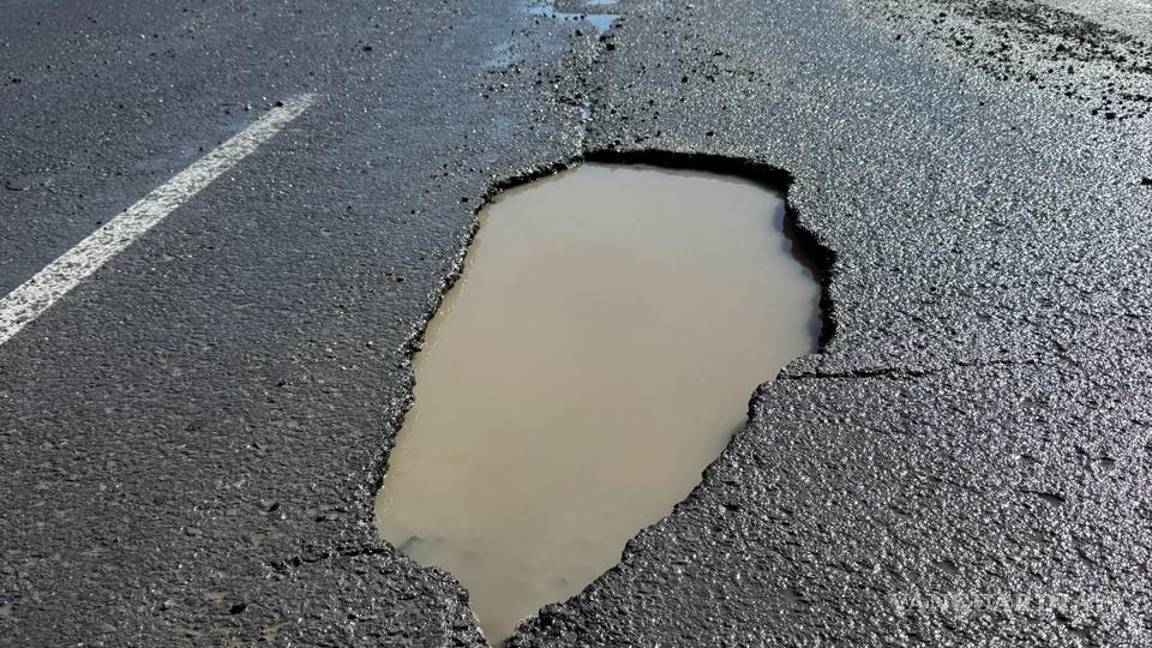 $!El acumulamiento de agua ocultó el bache, dificultando su detección por los conductores.