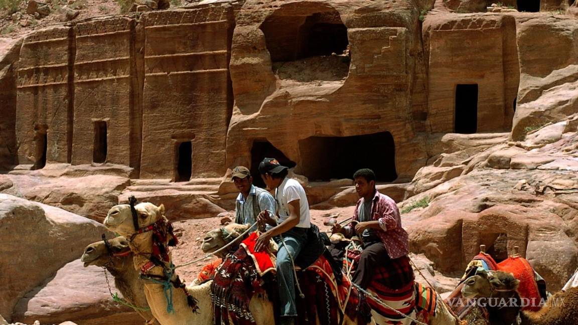 $!Grupo de beduinos en camello delante de algunas tumbas en el enclave arqueológico de Petra, en Jordania. EFE/Ballesteros/cg.