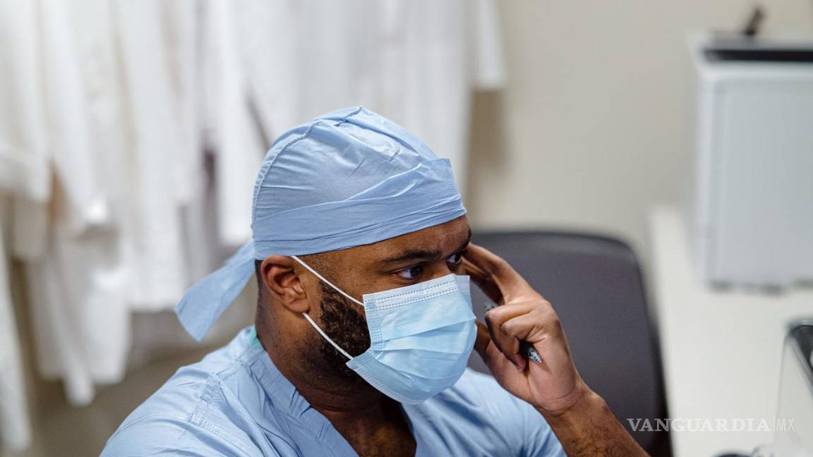 $!Myron Rolle revisa una lista de pacientes en una computadora durante su guardia nocturna en el Hospital General de Massachusetts en Boston.