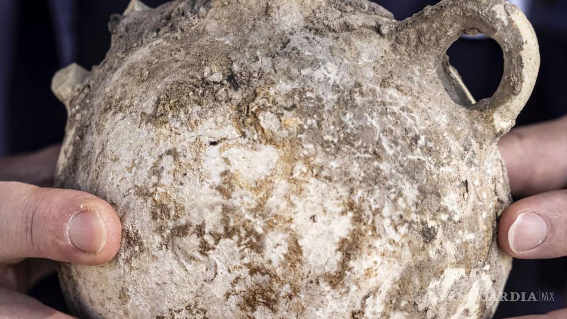$!Un empleado de la Autoridad de Antigüedades de Israel sostiene una jarra de un enorme complejo de vinificación antiguo que data de hace unos 1.500 años en Yavne, en el centro de Israel. AP/Tsafrir Abayov