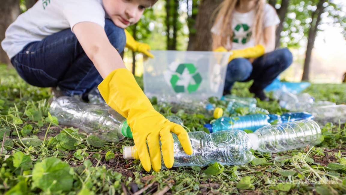 $!Niña y niño recolectan basura plástica en un parque para ser reciclada.