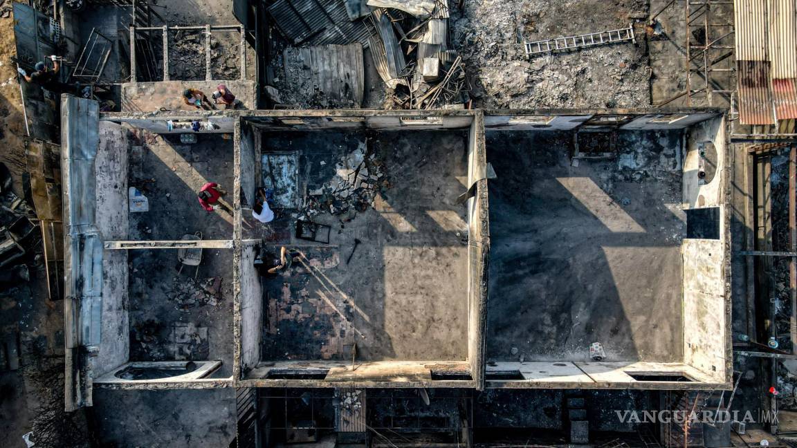 $!Un grupo de personas realiza labores de limpieza en medio de escombros en sus viviendas consumidas por las llamas de un incendio forestal en Viña del Mar.