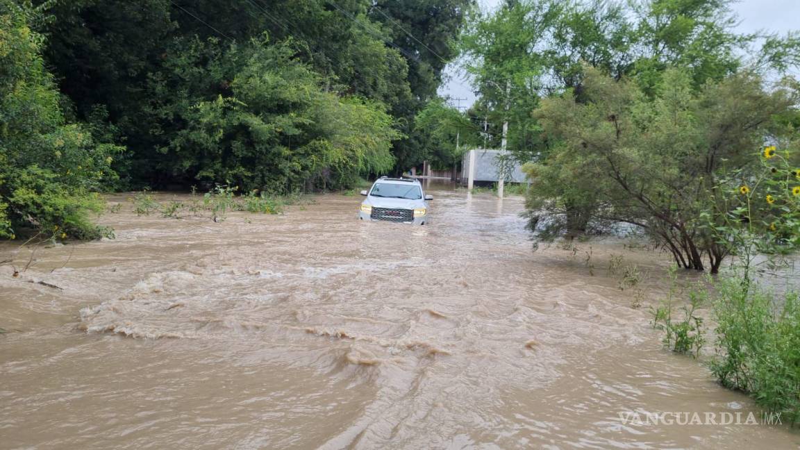 $!En Los Zertuche una mujer quedó atrapada en su camioneta al arriesgarse a cruzar el vado inundado.