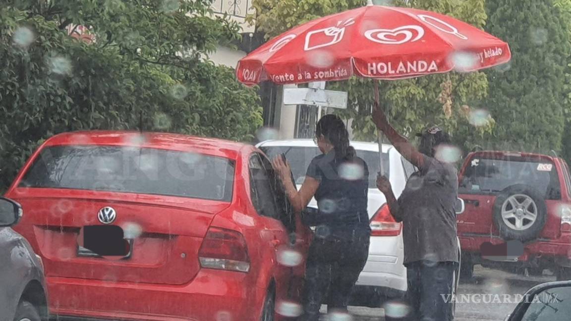 ‘Más gente como él’; captan a vendedor de Helados Holanda cubriendo a personas de la lluvia en Saltillo
