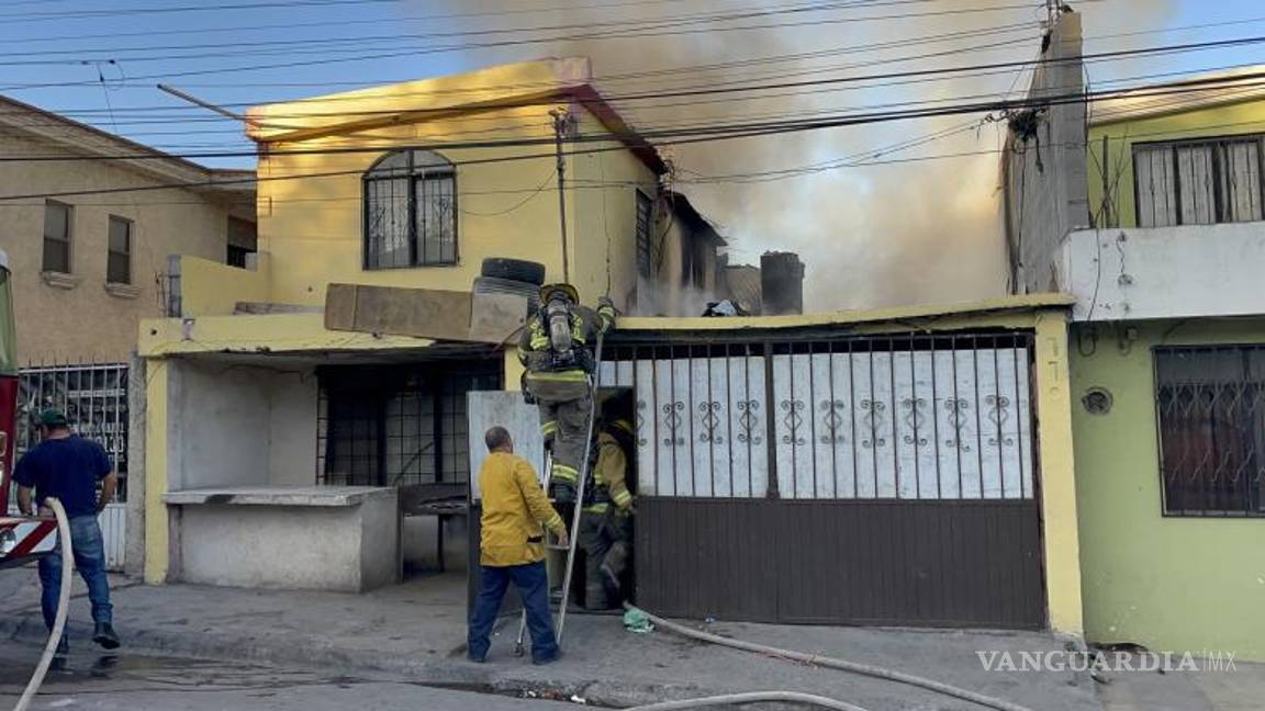 $!Los bomberos combaten las llamas desde lo alto de la casa, donde se encontraban bolsas llenas de ropa y muebles.