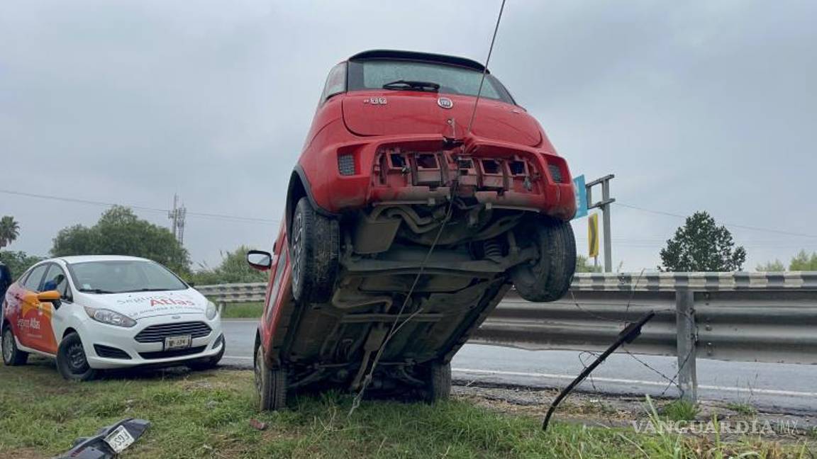 $!El vehículo Fiat Uno quedó suspendido sobre el cable tensor de un poste, evitando su caída al arroyo.