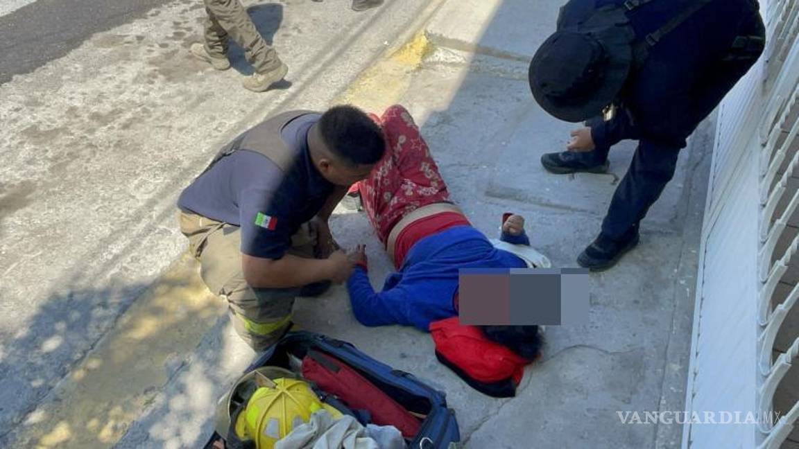 $!Una mujer, rescatada por las autoridades, es atendida por paramédicos después de inhalar humo durante el incendio en su casa.