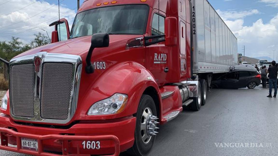 $!La mujer tuvo que ser extraía de su camioneta tras haber quedado atrapada debajo del tráiler.