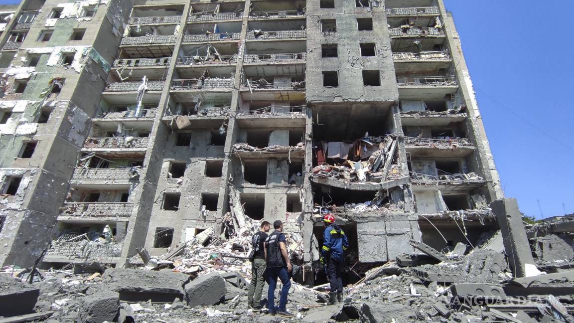 $!Los trabajadores de la fiscalía y los rescatistas en la escena de un edificio residencial dañado después de que los bombardeos en Serhiivka cerca de Odesa.