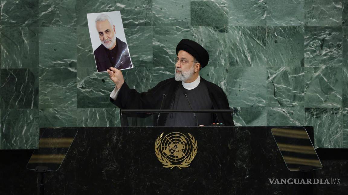 $!El presidente Ebrahim Raisi de Irán sostiene una foto de Qasem Soleimani mientras pronuncia su discurso en la Asamblea General .