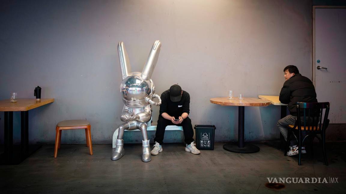 $!Los trabajadores hacen una pausa frente a un restaurante en Shanghái, China.
