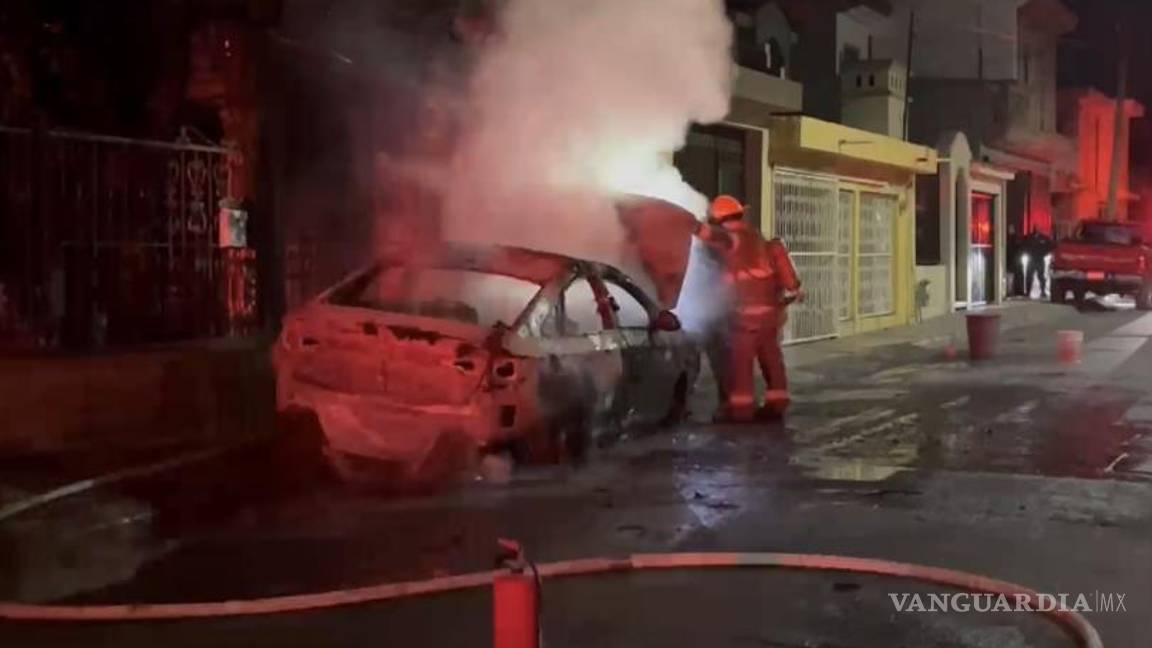 $!Policía y vecinos lucharon por apagar las llamas devoradoras que consumieron por completo el automóvil, sin poder evitar la destrucción total.