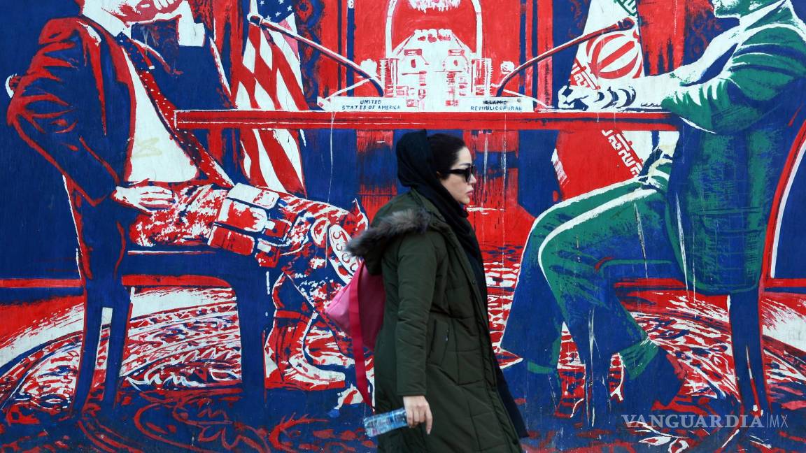 $!Una mujer iraní pasa junto a un mural antiestadounidense cerca de la antigua embajada de Estados Unidos en Teherán.