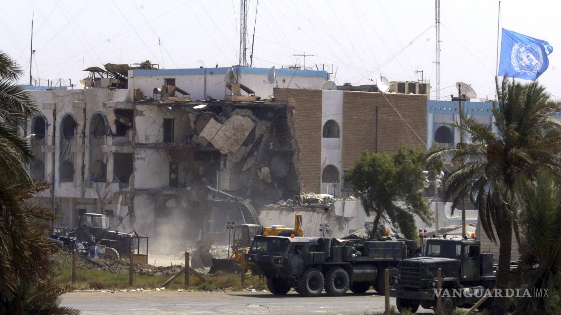 $!Vehículos militares estadounidenses pasan frente a la sección derrumbada de las oficinas de Naciones Unidas, el sábado 23 de agosto de 2003 en Bagdad, Irak.