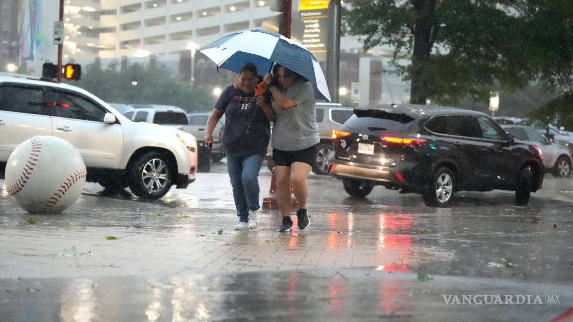 $!Los fanáticos se dirigen al Minute Maid Park mientras una fuerte tormenta golpea antes de un juego de béisbol entre los Atléticos de Oakland y los Astros de Houston.