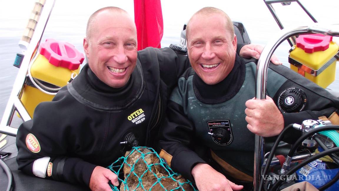 $!Julian y Lincoln Barnwell posan para una foto con la campana del HMS Gloucester, encontrada en 2007.