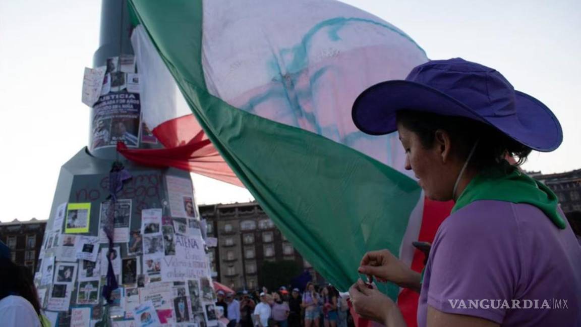 Colocan feministas su propia bandera tricolor en el Zócalo de la CDMX