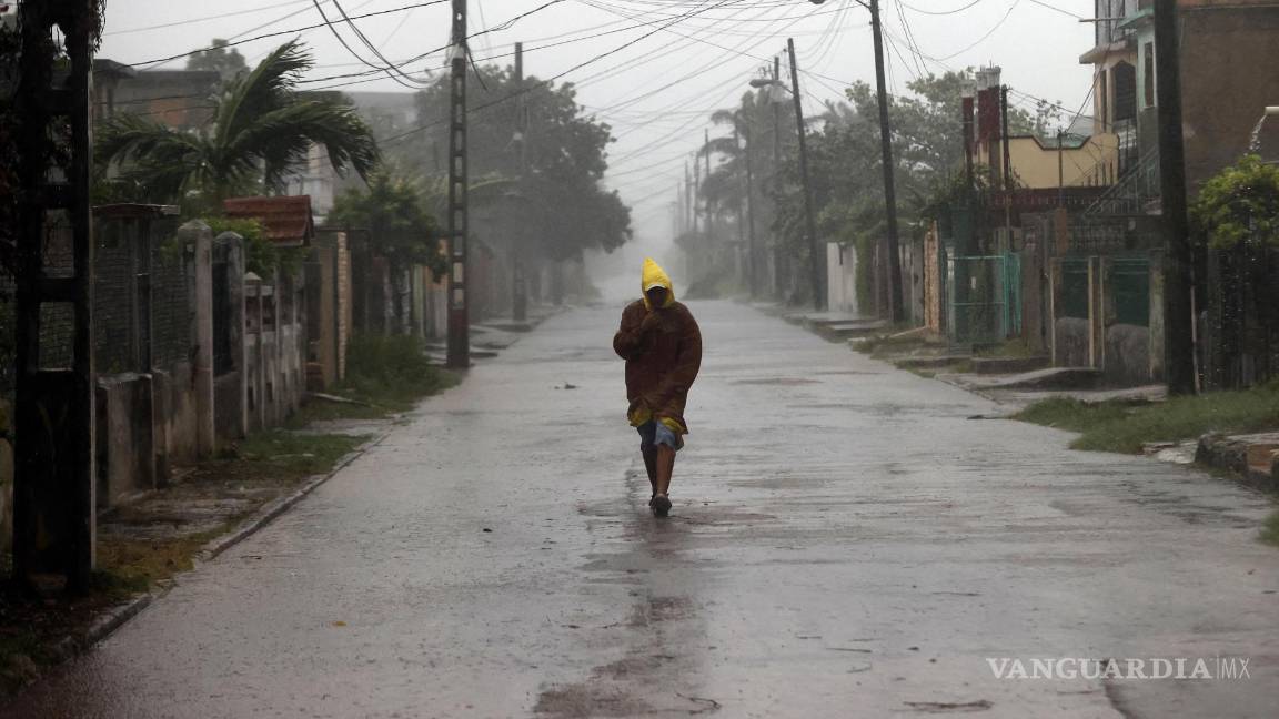 $!Un hombre camina en medio de la lluvia debido al paso del huracán Rafael en La Habana, Cuba.