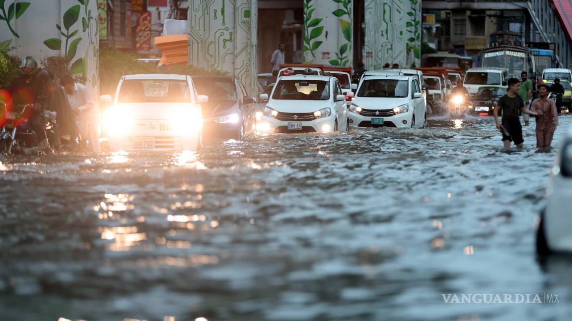 $!Los automovilistas se abren camino a través de una carretera inundada tras las fuertes lluvias monzónicas en Rawalpindi, Pakistán.