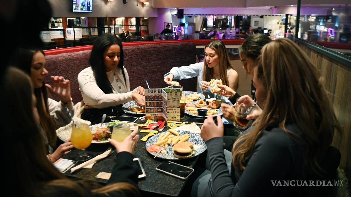 $!Un grupo de jóvenes comen en un restaurante de Londres. El alimento es el medio de civilización más ubicuo y siempre ha moldeado el mundo, pero no siempre para bien. EFE/EPA/Andy Rain