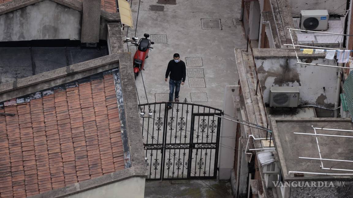$!Un hombre camina fuera de su casa en un complejo residencial en Shanghái, China.