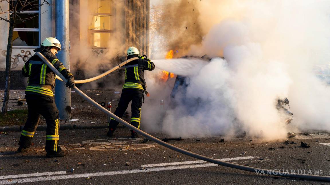 $!Los bomberos intentan extinguir un automóvil en llamas después de un ataque ruso en Kiev, Ucrania.