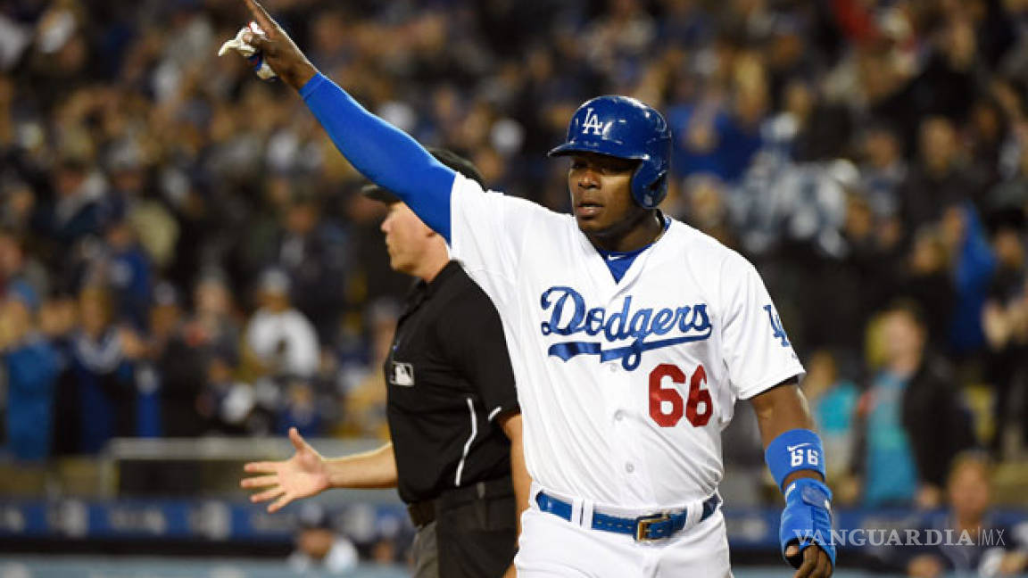 Yasiel Puig levanta la mano para jugar con el Tri de beisbol