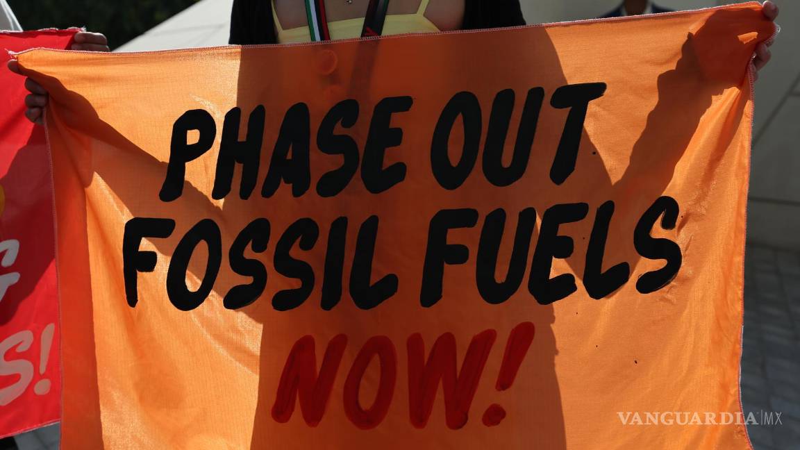 $!Activistas sostienen pancartas y gritan consignas pidiendo energía renovable mientras asisten al quinto día de la COP28 en Dubai.