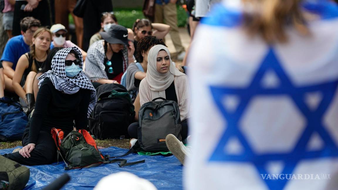 $!Un estudiante envuelto en una bandera israelí escucha a los manifestantes pro palestinos reunidos en el campus de la Universidad de Texas en Austin.