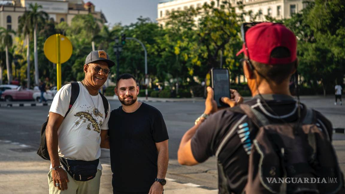 $!Elián González, en el centro, posa con un peatón que le pidió una foto mientras da una entrevista en La Habana, Cuba, el jueves 27 de junio de 2023.