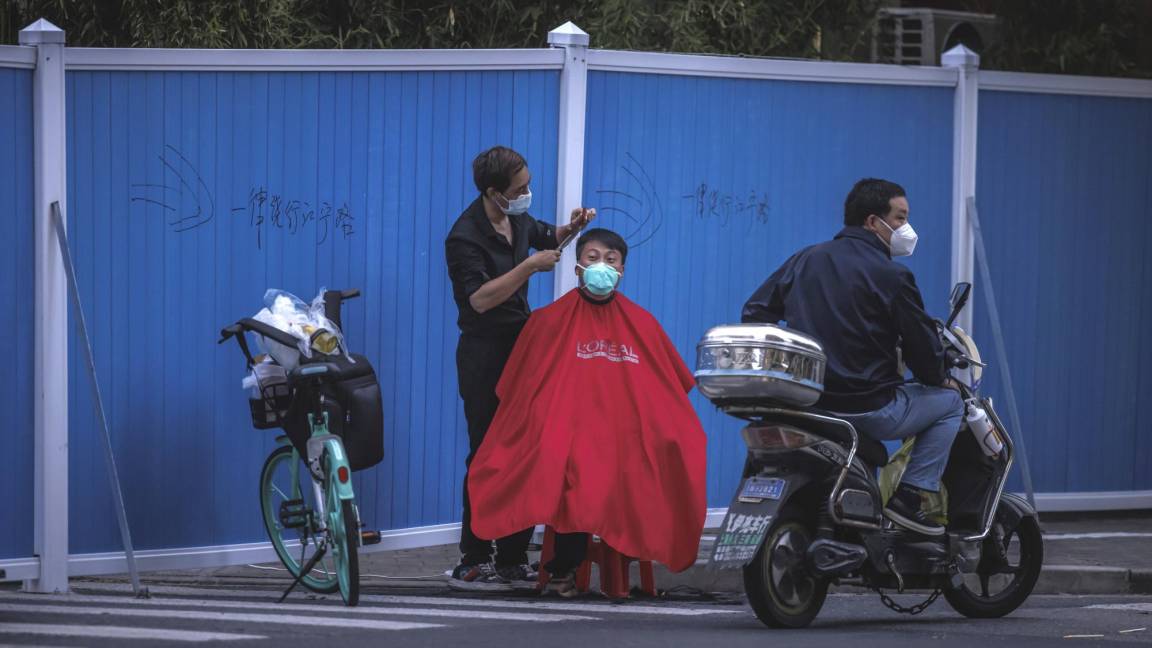 $!Un hombre se corta el pelo en la calle en medio del bloqueo de Covid-19 en curso en Shanghái, China.