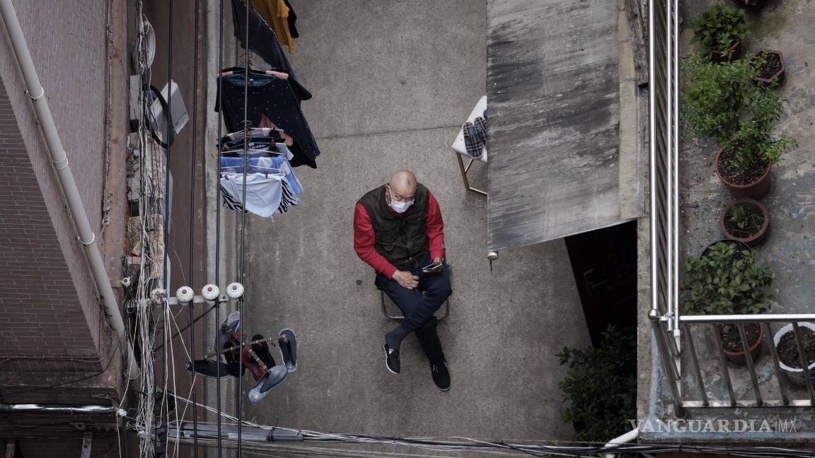 $!Un hombre se sienta afuera de su casa en un complejo residencial en Shanghái, China.