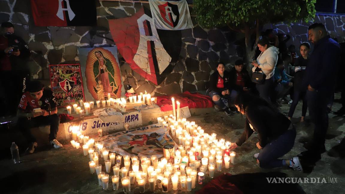 $!Aficionados del Club Atlas, encienden velas en la madrugada de este domingo, en las inmediaciones del estadio Jalisco, en la ciudad de Guadalajara, debido a los actos de violencia ocurridos en el partido.